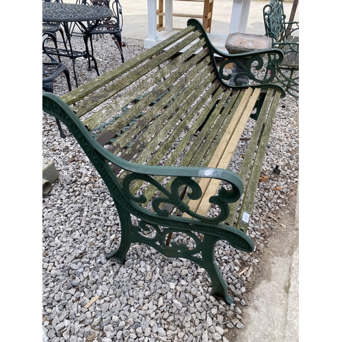 1976 - A WOODEN SLATTED GARDEN BENCH WITH CAST BENCH ENDS