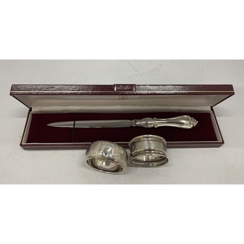 4 - A CASED HALLMARKED SILVER HANDLED LETTER OPENER AND TWO HALLMARKED SILVER NAPKIN RINGS, TOTAL WEIGHT... 