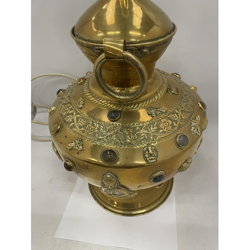 9 - A VINTAGE MIDDLE EASTERN DESIGN BRASS LAMP WITH EMBOSSED STONE AND BUDDHA DESIGN, HEIGHT 58CM