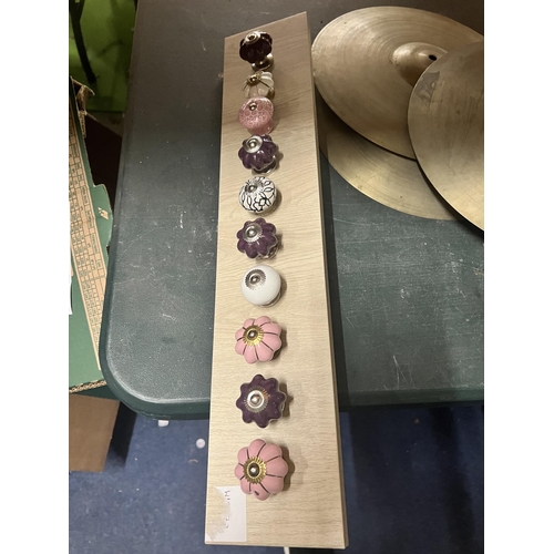 1096 - A QUANTITY OF MODERN DRAWER KNOBS ON A WOODEN BOARD