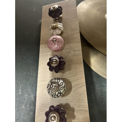 1096 - A QUANTITY OF MODERN DRAWER KNOBS ON A WOODEN BOARD