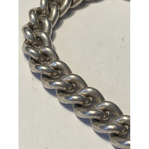 528 - A HEAVY SILVER CURB LINK BRACELET WITH MARKED 925 HEART CLASP