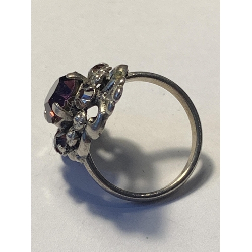 533 - A SILVER RING WITH A LARGE CENTRE PURPLE STONE IN A PRESENTATION BOX