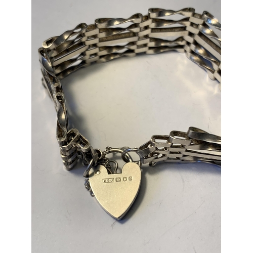 566 - A SILVER FIVE BAR GATE BRACELET WITH HEART CLASP