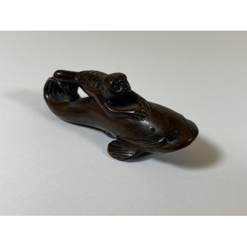 336 - AN ORIENTAL NETSUKE OF A TURTLE MONKEY RIDING A NAMAZU (EARTHQUAKE FISH) SIGNED TO BASE, LENGTH 6.5C... 