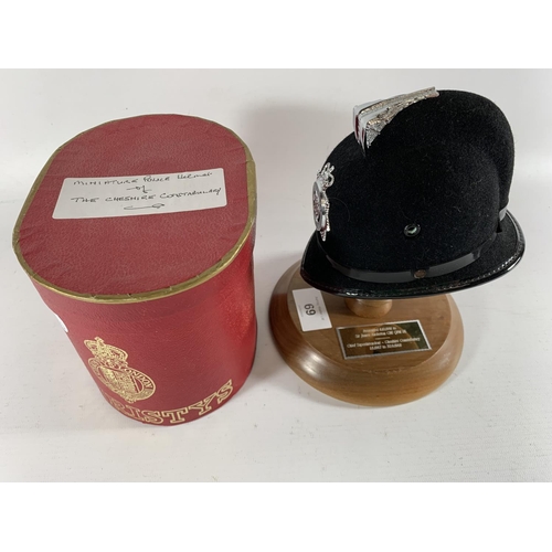 69 - * A PRESENTATION MINIATURE CHESHIRE CONSTABULARY HELMET BY CHRISTYS, MOUNTED ON A WOODEN STAND, PRES... 