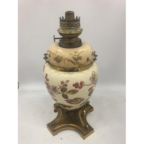 13 - AN ANTIQUE CERAMIC AND BRASS OIL LAMP WITH FLORAL DESIGN