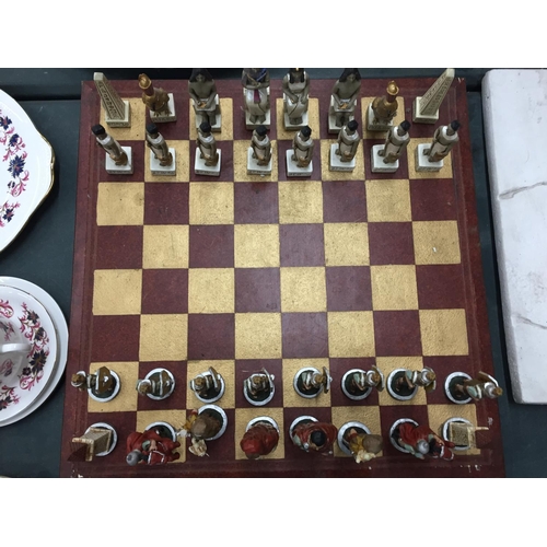 104 - A HEAVY VINTAGE CHESS BOARD COMPLETE WITH ROMANS AND EGYPTIANS CHESS PIECES