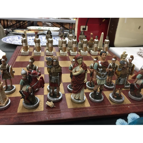 104 - A HEAVY VINTAGE CHESS BOARD COMPLETE WITH ROMANS AND EGYPTIANS CHESS PIECES