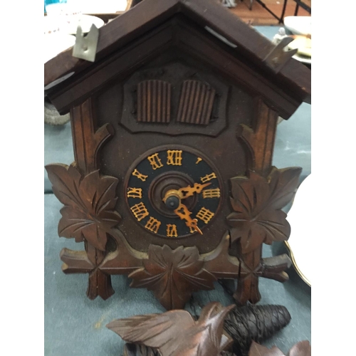 108 - A WOODEN CUCKOO CLOCK COMPLETE WITH PENDULUM AND WEIGHTS