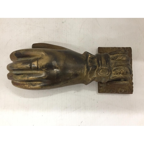 126 - A HEAVY VINTAGE BRASS DOOR KNOCKER IN THE SHAPE OF A HAND