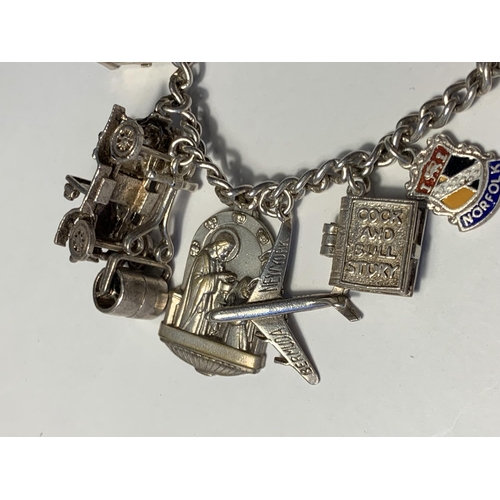 613 - A SILVER CHARM BRACELET WITH FIFTEEN CHARMS AND A HALLMARKED BIRMINGHAM SILVER HEART LOCK