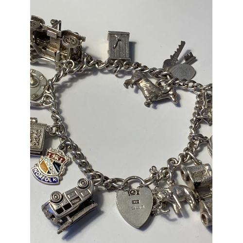 613 - A SILVER CHARM BRACELET WITH FIFTEEN CHARMS AND A HALLMARKED BIRMINGHAM SILVER HEART LOCK