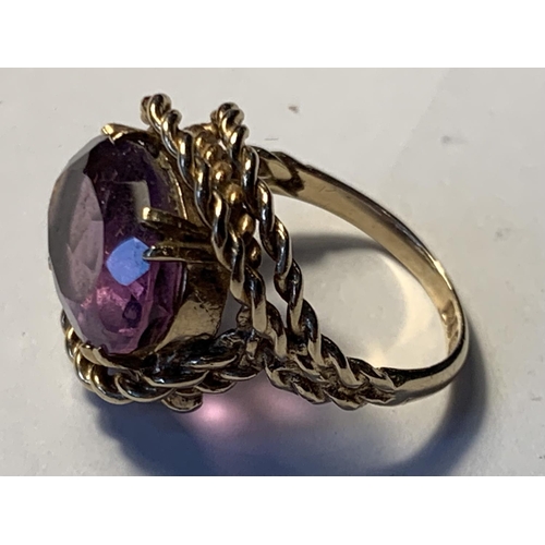 618 - A 9 CARAT GOLD RING WITH LARGE CENTRE AMETHYST SIZE L/M IN A HEART SHAPED PRESENTATION BOX