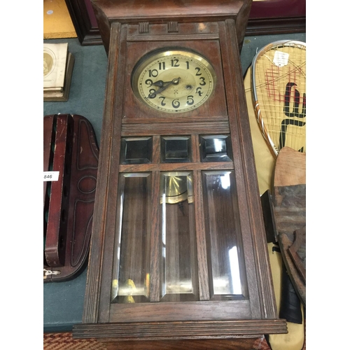 845 - A VINTAGE MAHOGANY CASED WALL CLOCK WITH BEVELLED GLASS TO THE FRONT, COMPLETE WITH PENDULUM AND KEY... 