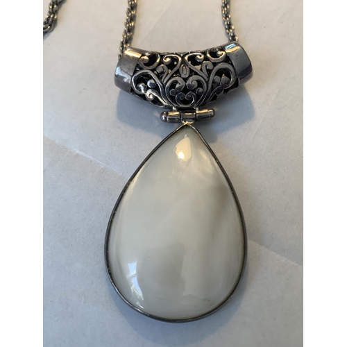 669 - A SILVER NECKLACE WITH A LARGE PEARLISED STONE PENDANT