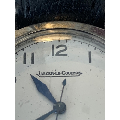 690 - A VINTAGE JAEGER LeCOUTRE WRIST WATCH WITH WHITE FACE AND BLACK LEATHER STRAP POSSIBLY MILITARY. SEE... 