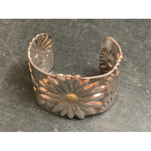 675 - A HEAVY AND DECORATIVE SILVER PLATED BANGLE WITH FLORAL DECORATION