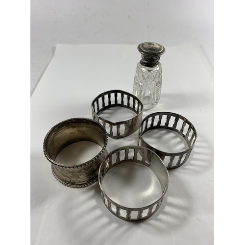 700A - FOUR SILVER NAPKIN RINGS AND A SILVER LIDDED PERFUME BOTTLE WITH STOPPER