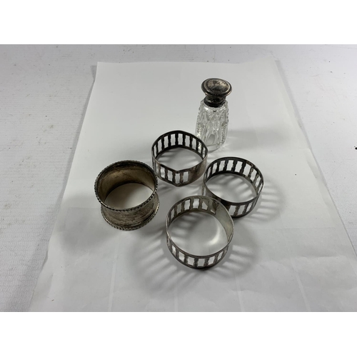 700A - FOUR SILVER NAPKIN RINGS AND A SILVER LIDDED PERFUME BOTTLE WITH STOPPER