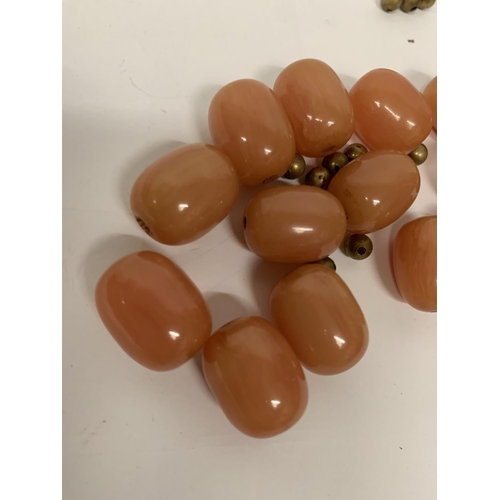 696 - FOURTEEN AMBER BEADS AND YELLOW METAL SPACER BEADS