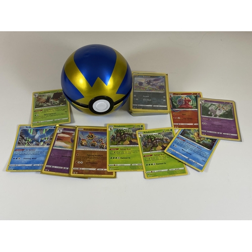 105 - A POKEMON BALL TIN CONTAINING ASSORTED POKEMON CARDS, HOLOS, RARES ETC