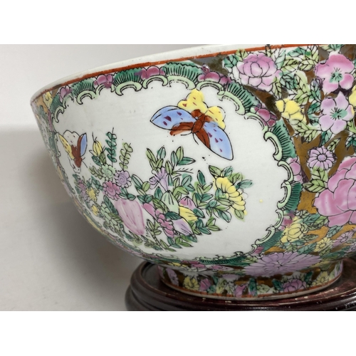 355 - A LARGE CHINESE CANTON FAMILLE ROSE PUNCH BOWL DECORATED WITH ENAMELLED FIGURAL DESIGN ON A TURNED W... 