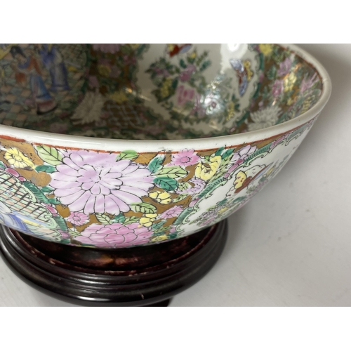 355 - A LARGE CHINESE CANTON FAMILLE ROSE PUNCH BOWL DECORATED WITH ENAMELLED FIGURAL DESIGN ON A TURNED W... 