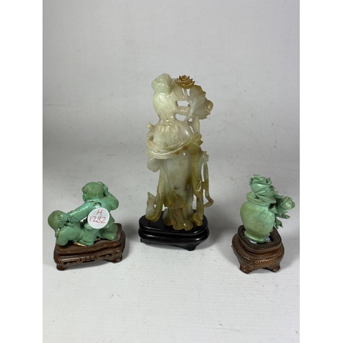 391 - A GROUP OF THREE ORIENTAL FIGURES ON STANDS TO INCLUDE A JADE TYPE HARDSTONE FIGURE, HEIGHT 16.5CM