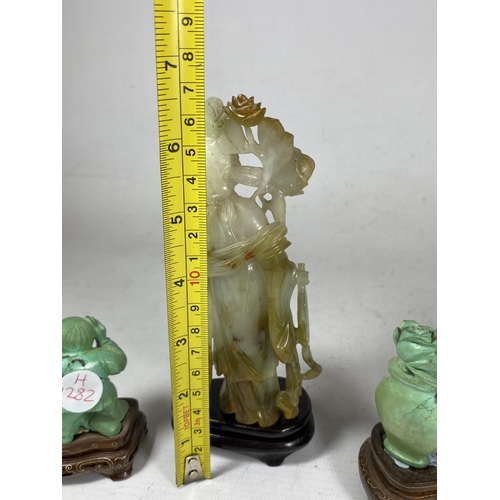 391 - A GROUP OF THREE ORIENTAL FIGURES ON STANDS TO INCLUDE A JADE TYPE HARDSTONE FIGURE, HEIGHT 16.5CM