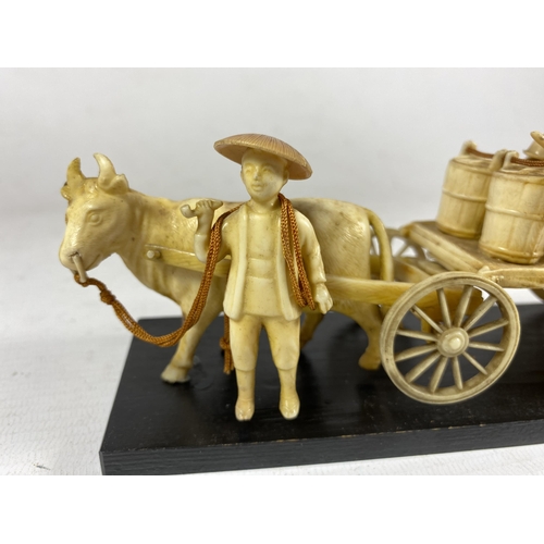 397 - AN ORIENTAL BONE EFFECT MODEL OF A CHINESE MAN WITH HORSE AND CART