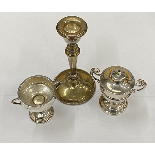 4 - A GROUP OF THREE HALLMARKED SILVER ITEMS COMPRISING A WEIGHTED CANDLESTICK, LIGHTER AND TWIN HANDLED... 