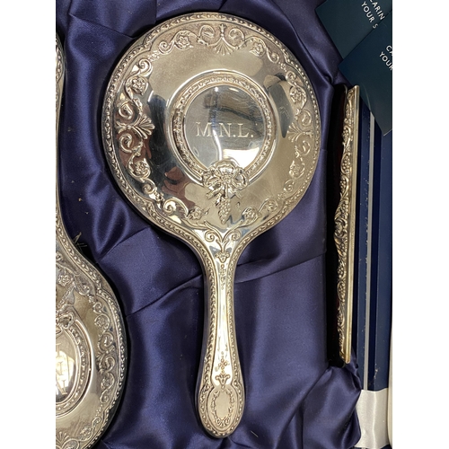 34 - A CASED HALLMARKED SILVER BACKED THREE PIECE DRESSING SET COMPRISING COMB, MIRROR AND BRUSH