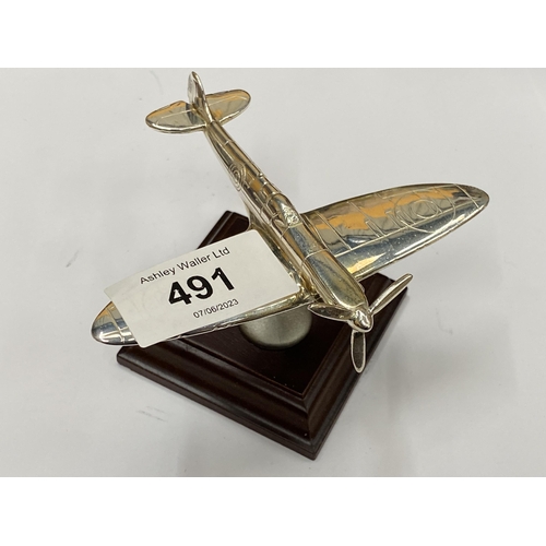 491 - A SMALL CHROME EFFECT MODEL OF A SPITFIRE AEROPLANE