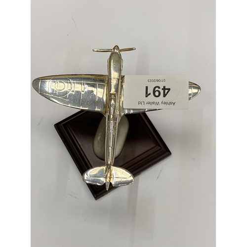 491 - A SMALL CHROME EFFECT MODEL OF A SPITFIRE AEROPLANE