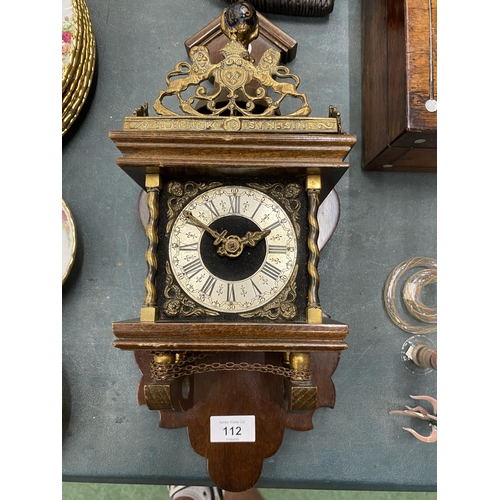 112 - A VINTAGE MAHOGANY CASED WALL CLOCK WITH BRASS DECORATION - LACKING KEY, AND WEIGHTS