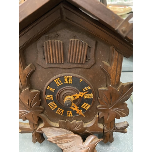 113 - A WOODEN CUCKOO CLOCK COMPLETE WITH PENDULUM AND WEIGHTS