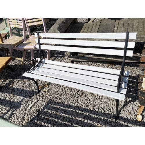 1987 - A WOODEN SLATTED GARDEN BENCH WITH CAST ENDS