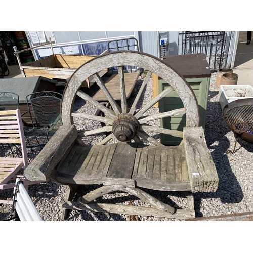 1990 - A DECORATIVE WOODEN GARDEN BENCH WITH CART WHEEL BACK