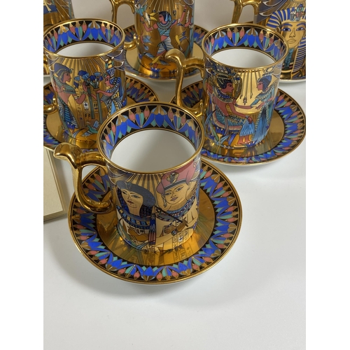 723 - A COMPTON AND WOODHOUSE 'THE WONDERS OF THE NILE' TUTANKHAMUN GILT SET OF SIX CUPS AND SAUCERS WITH ... 