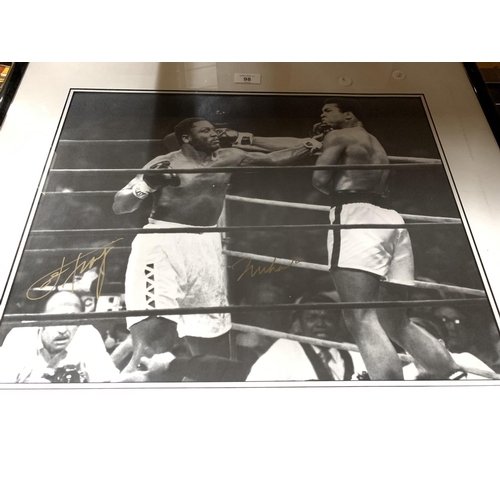 98A - A SIGNED AND FRAMED BLACK AND WHITE PHOTOGRAPH OF MUHAMMED ALI AND JOE FRAZIER WITH CERTIFICATE