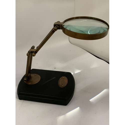 192 - A BRASS MAGNIFYING GLASS ON A WOODEN BASE