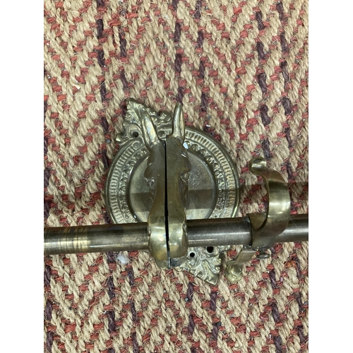 818 - A VINTAGE BRASS CURTAIN POLE WITH HORSE HEAD BRACKETS