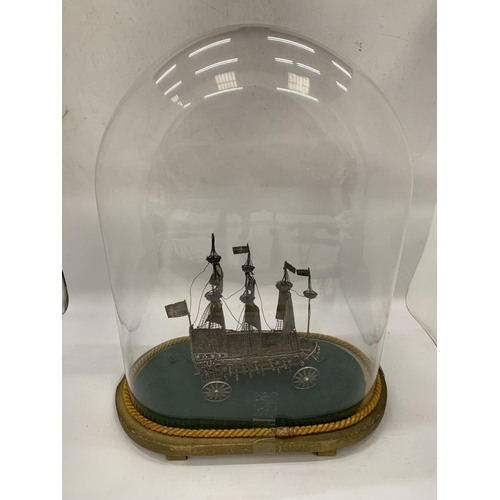 15 - A VINTAGE WHITE METAL, POSSIBLY SILVER, BOAT MODEL IN VINTAGE GLASS DOME CASE, DOME HEIGHT 46CM