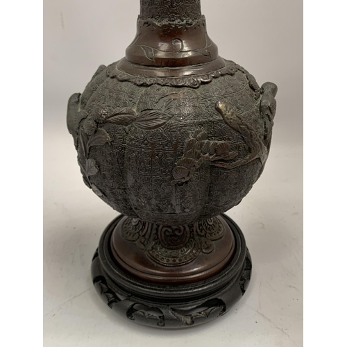 33 - AN ORIENTAL ORNATE BRONZE VASE ON WOODEN BASE, HEIGHT 34CM