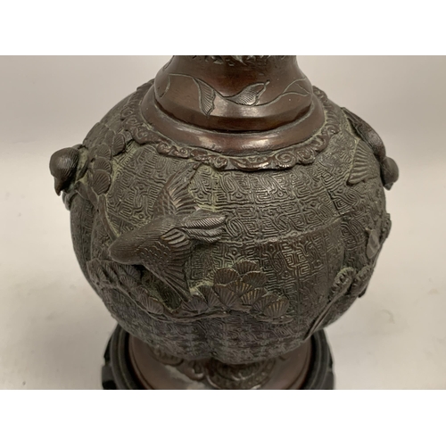 33 - AN ORIENTAL ORNATE BRONZE VASE ON WOODEN BASE, HEIGHT 34CM