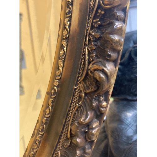 66 - A GILT FRAMED BEVEL EDGED OVAL WALL MIRROR