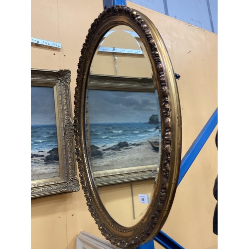 66 - A GILT FRAMED BEVEL EDGED OVAL WALL MIRROR