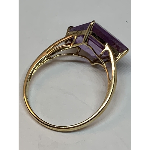 511 - A 10 CARAT GOLD RING WITH A PURPLE DIAMOND SHAPED STONE SIZE O