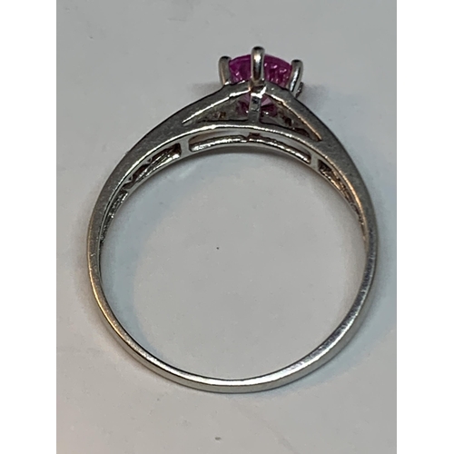 678 - A 9 CARAT WHITE GOLD RING WITH A PINK SAPPHIRE AND CUBIC ZIRCONIAS ON THE SHOULDERS SIZE M/N